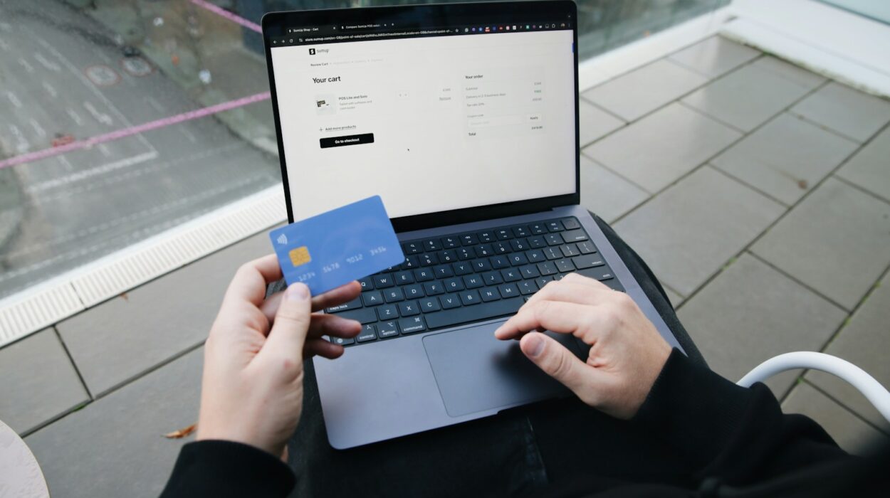 A person sitting in a chair with a laptop and a credit card